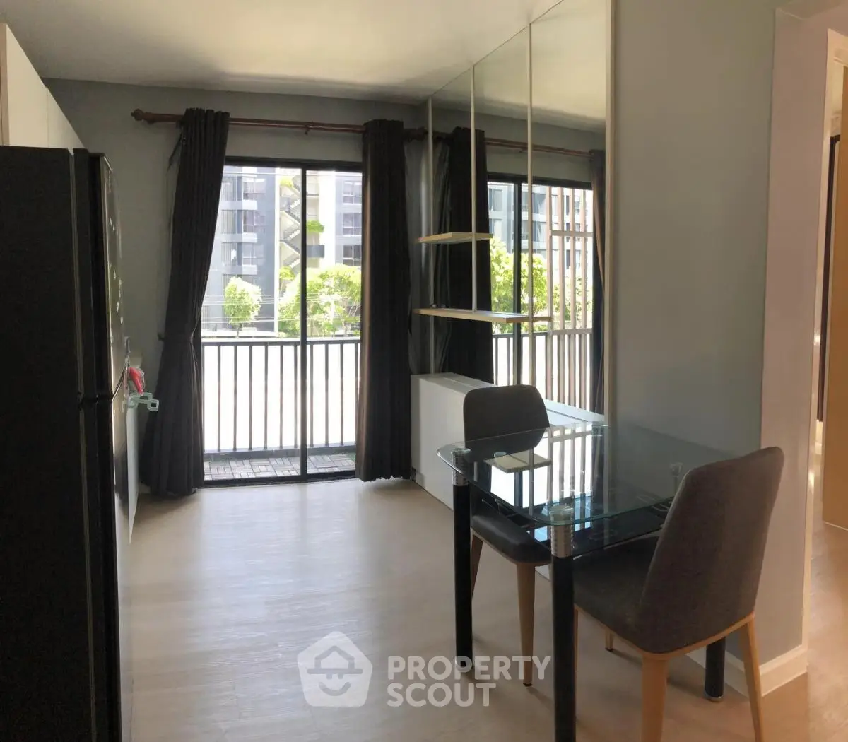 Modern dining area with glass table and balcony view in sleek apartment
