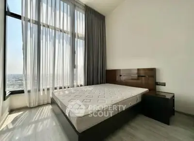 Spacious bedroom with large windows offering stunning city views, modern design and ample natural light.