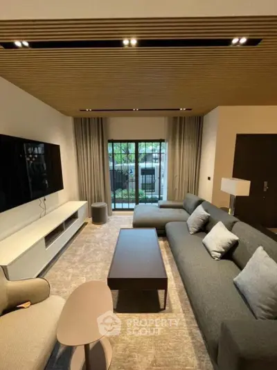 Modern living room with stylish furniture and large window view.