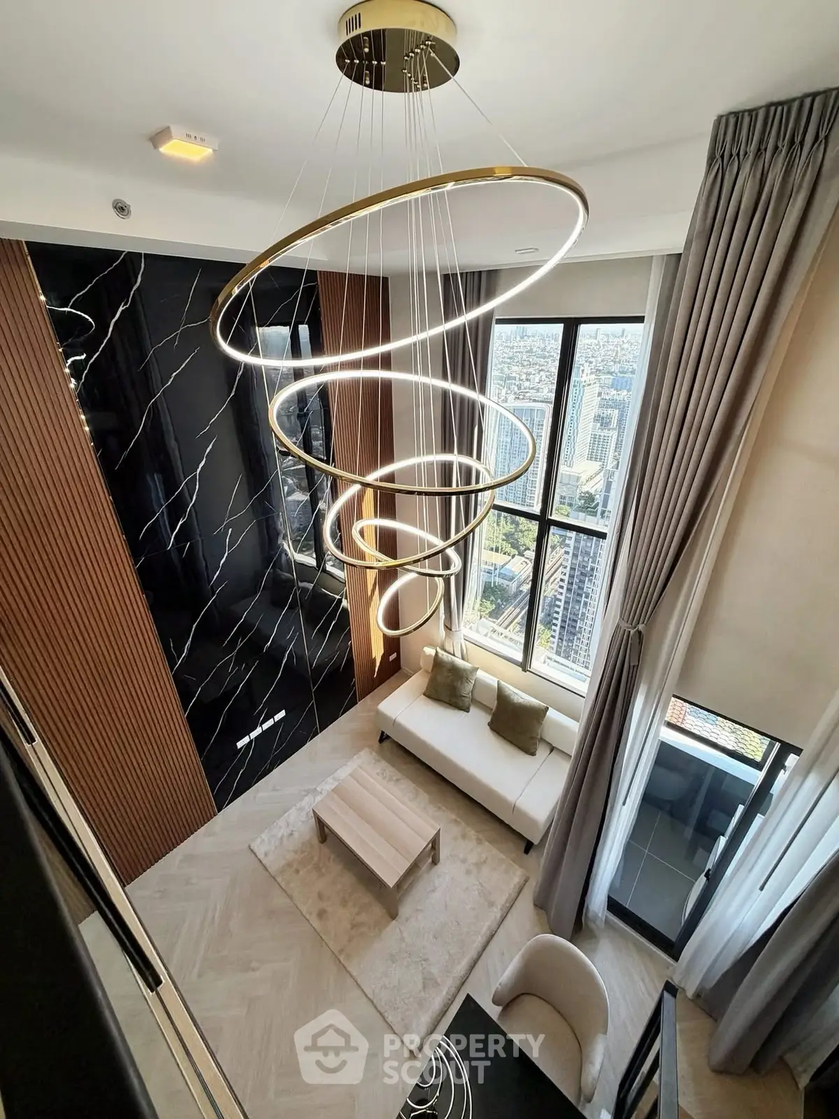 Luxurious high-rise living room with stunning city view and modern spiral chandelier.