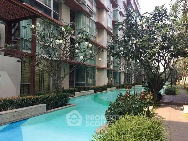 Luxurious condominium with serene pool and lush garden view