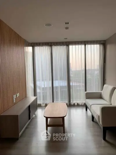 Modern living room with floor-to-ceiling windows and stylish furniture