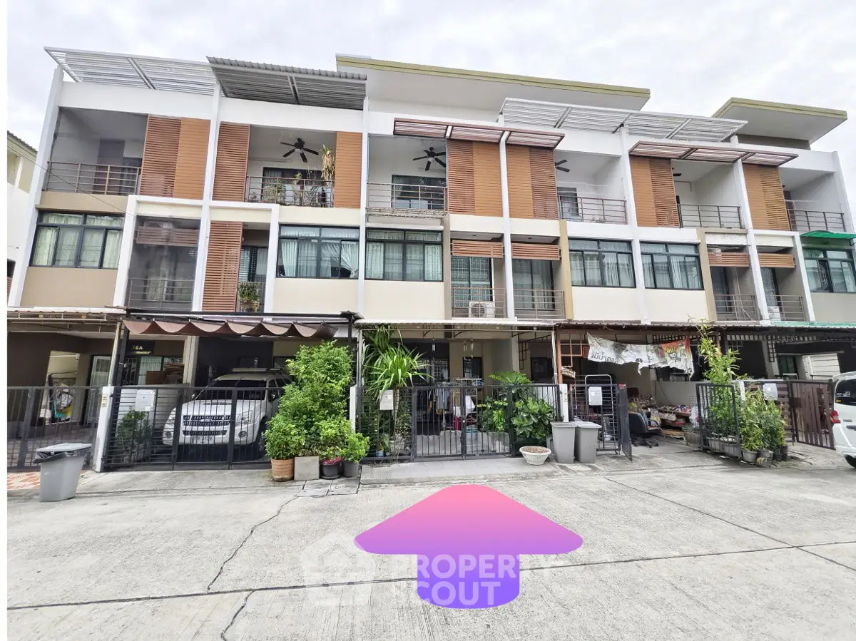 Modern townhouse exterior with multiple balconies and carport in a suburban neighborhood.