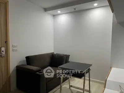 Cozy compact living room with modern sofa and sleek table, perfect for urban living.