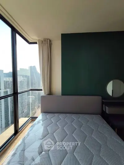 Modern bedroom with large windows offering stunning city views and stylish decor.