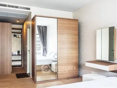 Modern bedroom with mirrored wardrobe and sleek wooden furniture