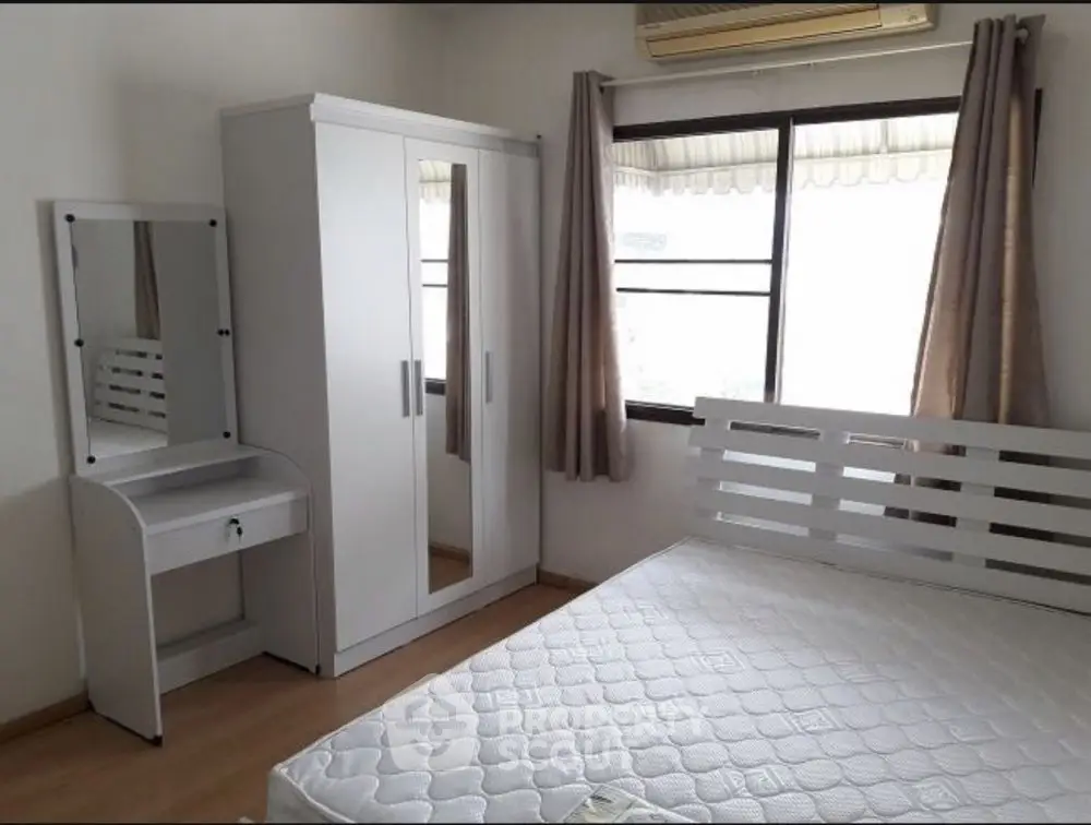Bright bedroom with white furniture and large window