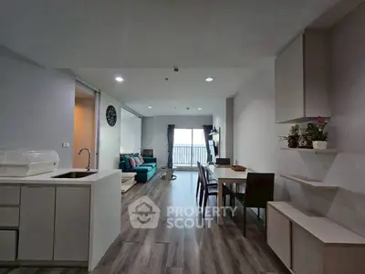 Modern open-plan living room and kitchen with sleek design and natural light.
