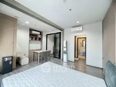 Modern studio apartment with open layout and sleek furnishings, featuring a cozy study area and spacious bedroom.