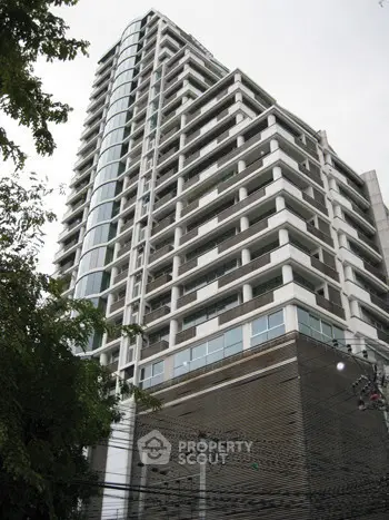 Modern high-rise building with sleek architecture and glass facade in urban setting.