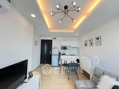 Modern living room with open kitchen, stylish lighting, and cozy seating area.
