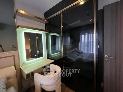 Modern bedroom with sleek mirrored wardrobe and illuminated vanity area.