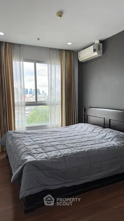 Spacious bedroom with city view and modern air conditioning unit, perfect for urban living.