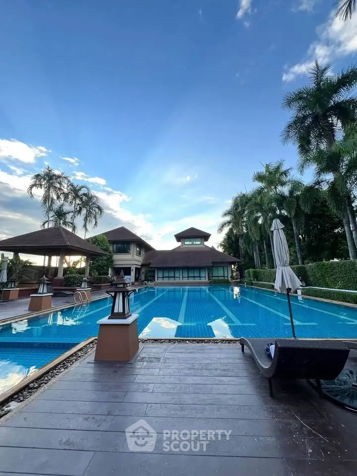Luxurious villa with stunning pool and lush palm trees, perfect for tropical living.