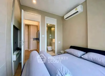 Modern bedroom with ensuite bathroom and air conditioning in a stylish apartment.