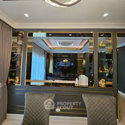 Luxurious living room with elegant decor and plush seating, featuring a large mirror and ambient lighting.