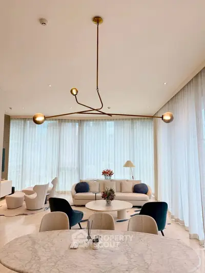 Luxurious modern living room with elegant lighting and stylish furniture, featuring floor-to-ceiling windows.