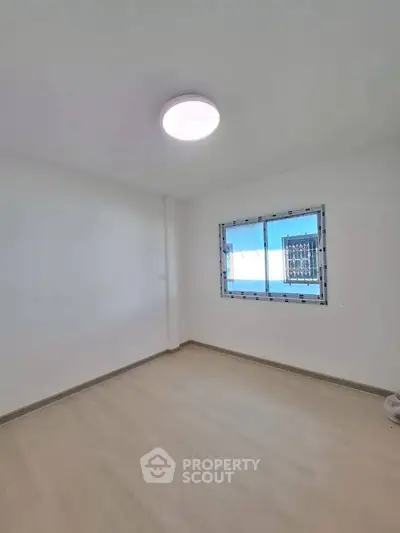 Bright empty room with large window and modern ceiling light