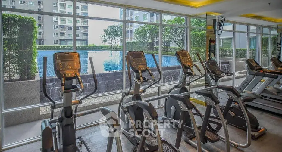 Modern gym with pool view in luxury apartment complex