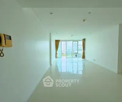 Spacious empty living room with city view and large windows in modern apartment.