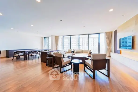 Spacious modern living room with large windows and elegant wooden flooring.