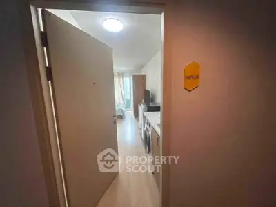 Cozy apartment entrance with a view into a bright living space featuring modern appliances.