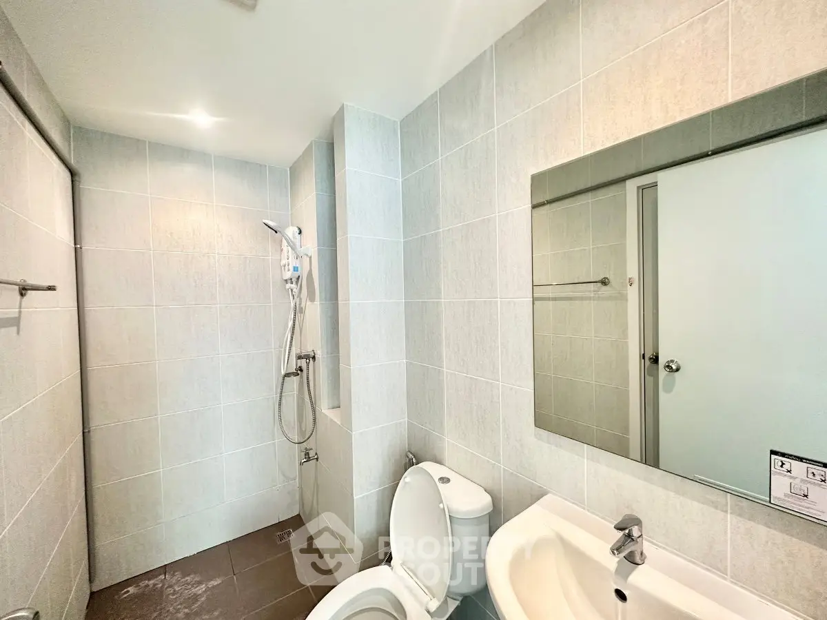 Modern bathroom with sleek fixtures and spacious shower area in a contemporary home.