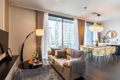 Luxurious living room with modern decor and city view, featuring elegant dining area and stylish furnishings.