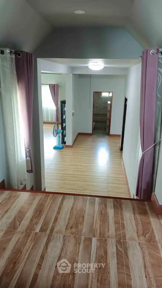 Spacious interior with wooden flooring and natural light, ideal for modern living.