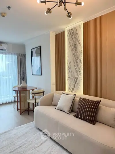 Modern living room with stylish decor and natural light, featuring a cozy sofa and elegant dining area.