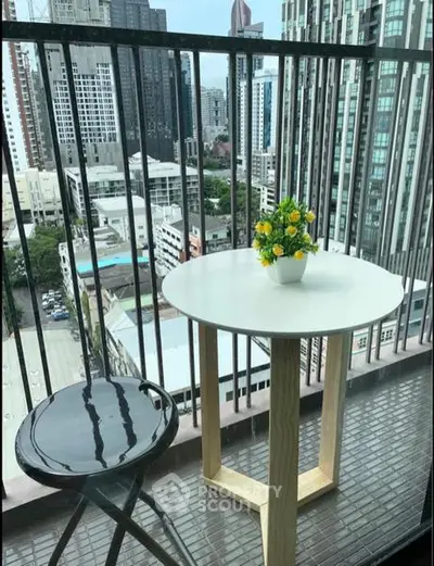 Charming balcony with city view, featuring a modern table and chair set, perfect for relaxation.