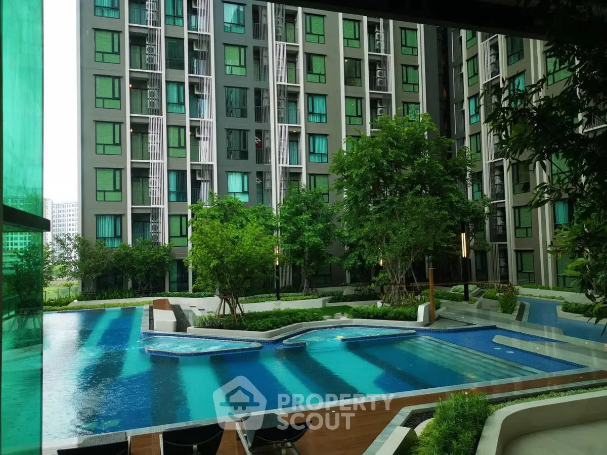 Modern apartment complex with luxurious pool and lush greenery