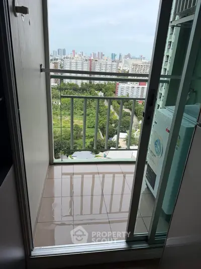 High-rise apartment balcony with stunning cityscape view and modern glass railing.