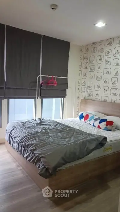 Cozy bedroom with modern decor and ample natural light, featuring stylish wall art and comfortable bedding.