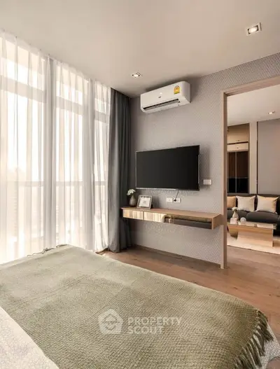Modern bedroom with large windows, wall-mounted TV, and stylish decor