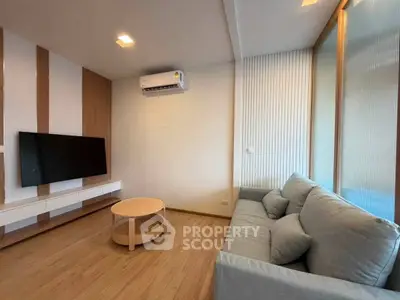Modern living room with sleek design, featuring a wall-mounted TV, air conditioning, and cozy seating.