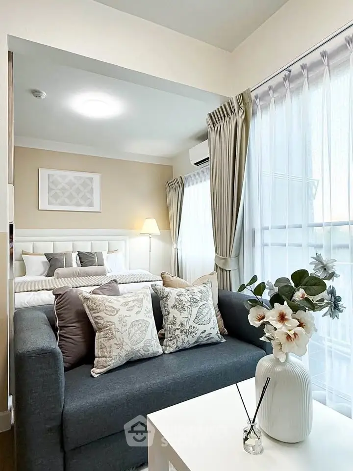 Chic modern living room with cozy sofa, elegant decor, and natural light from large windows.
