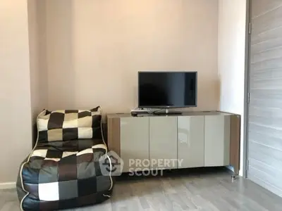 Modern living room with stylish bean bag chair and sleek TV cabinet.