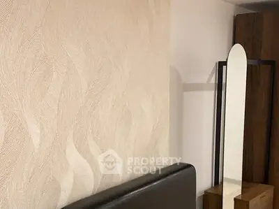 Modern bedroom with stylish wallpaper and sleek furniture design.