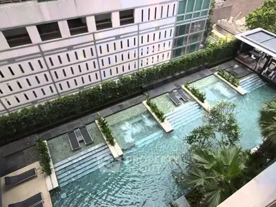 Luxurious rooftop pool with modern design and lush greenery in urban setting.