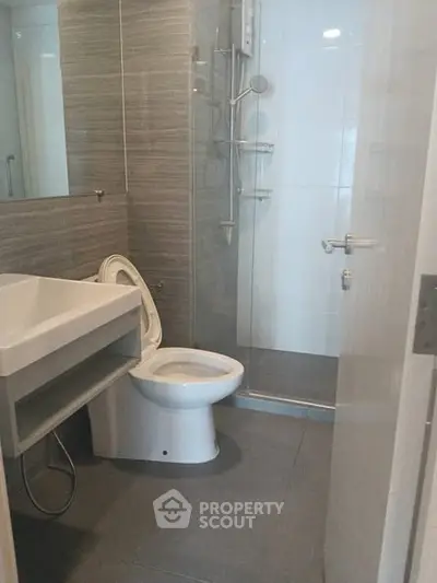 Modern bathroom with sleek design, featuring a glass shower and contemporary fixtures.