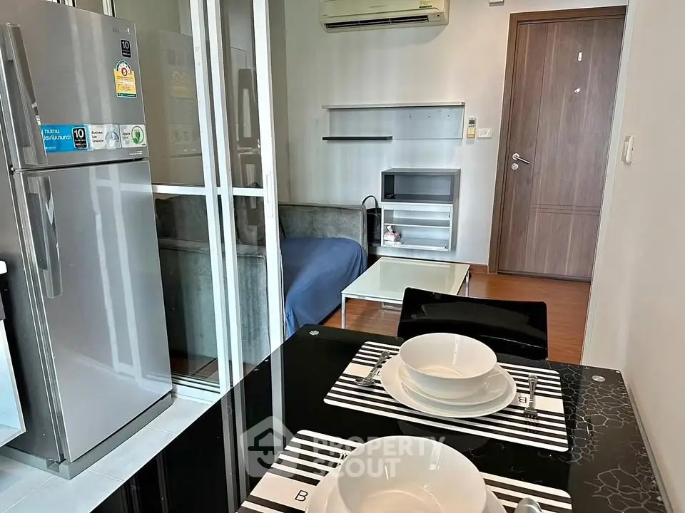 Modern apartment interior with dining area, cozy living room, and sleek kitchen appliances.