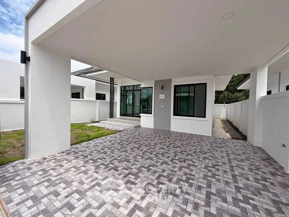 Modern single-story home with spacious driveway and sleek exterior design.