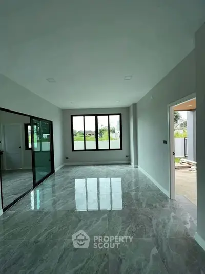 Spacious modern living room with large windows and glossy marble flooring