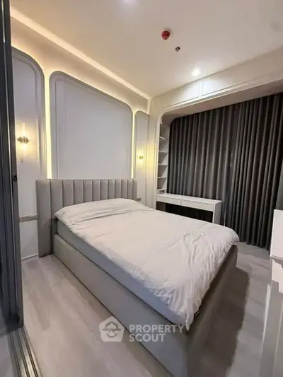 Modern bedroom with elegant lighting and sleek design, featuring a comfortable bed and stylish decor.