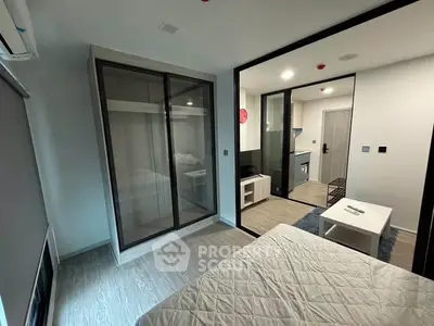 Modern studio apartment with open layout and sleek design, featuring a cozy bedroom and compact kitchen.