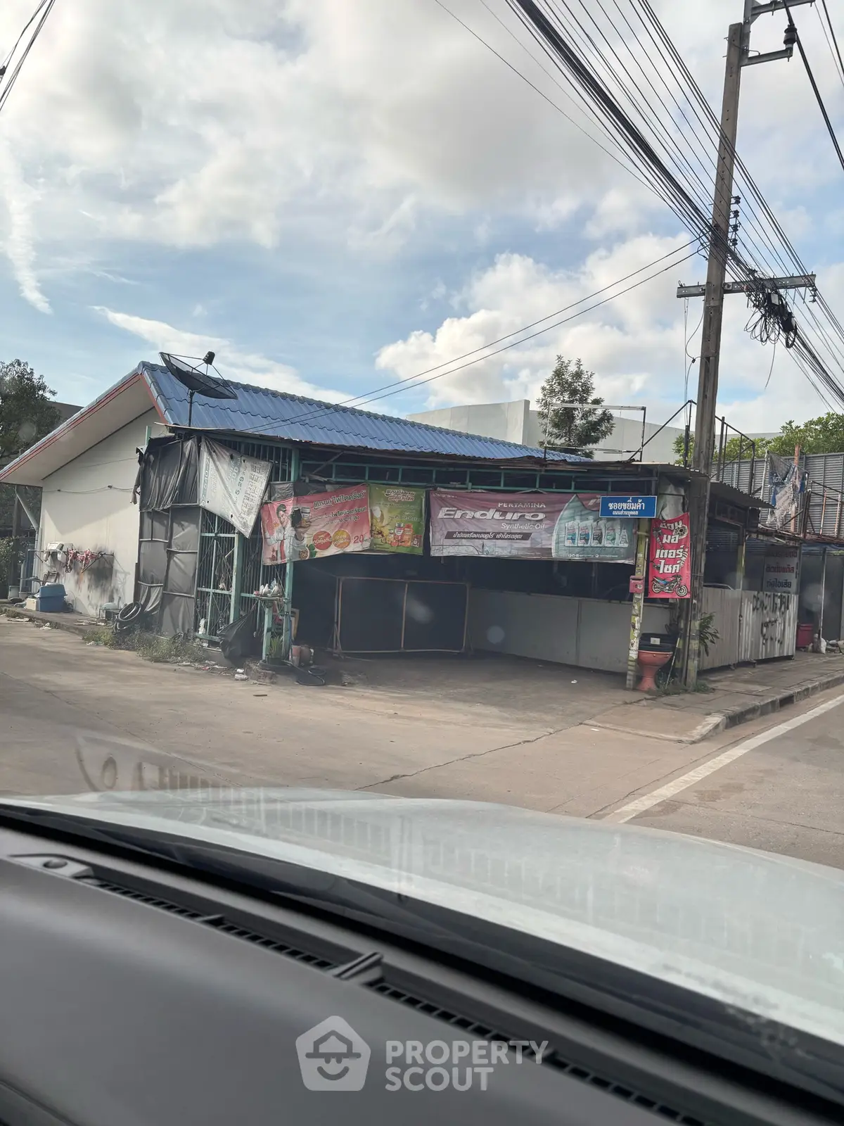 Street view of a small commercial building with signage and parking area.