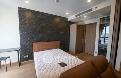 Modern bedroom with stylish accent wall and comfortable furnishings in a contemporary apartment.