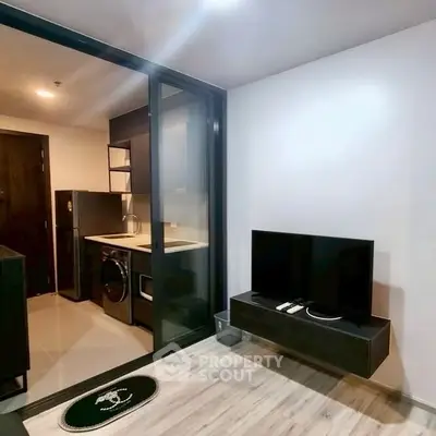 Modern apartment with sleek kitchen and cozy living area, featuring stylish appliances and contemporary design.