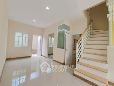 Spacious modern interior with elegant staircase and glossy tiled flooring